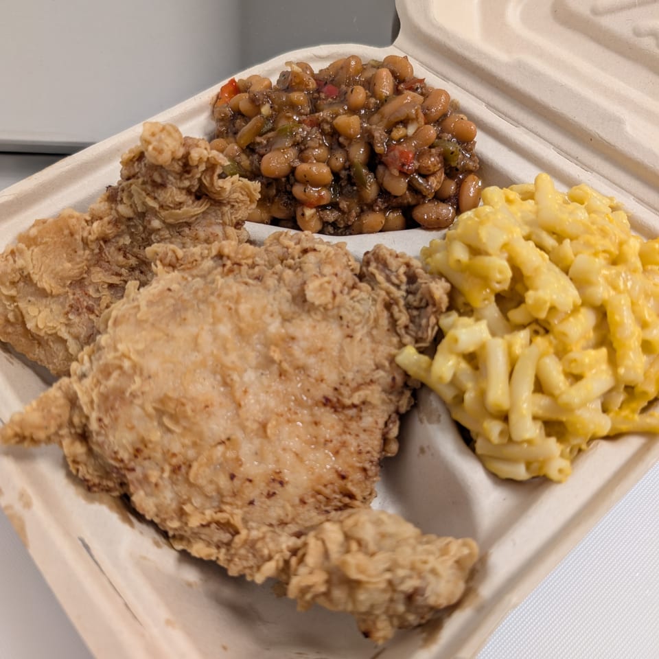 Fried chicken, baked beans, and macaroni and cheese in a takeout container from Cap Hill Burgers.