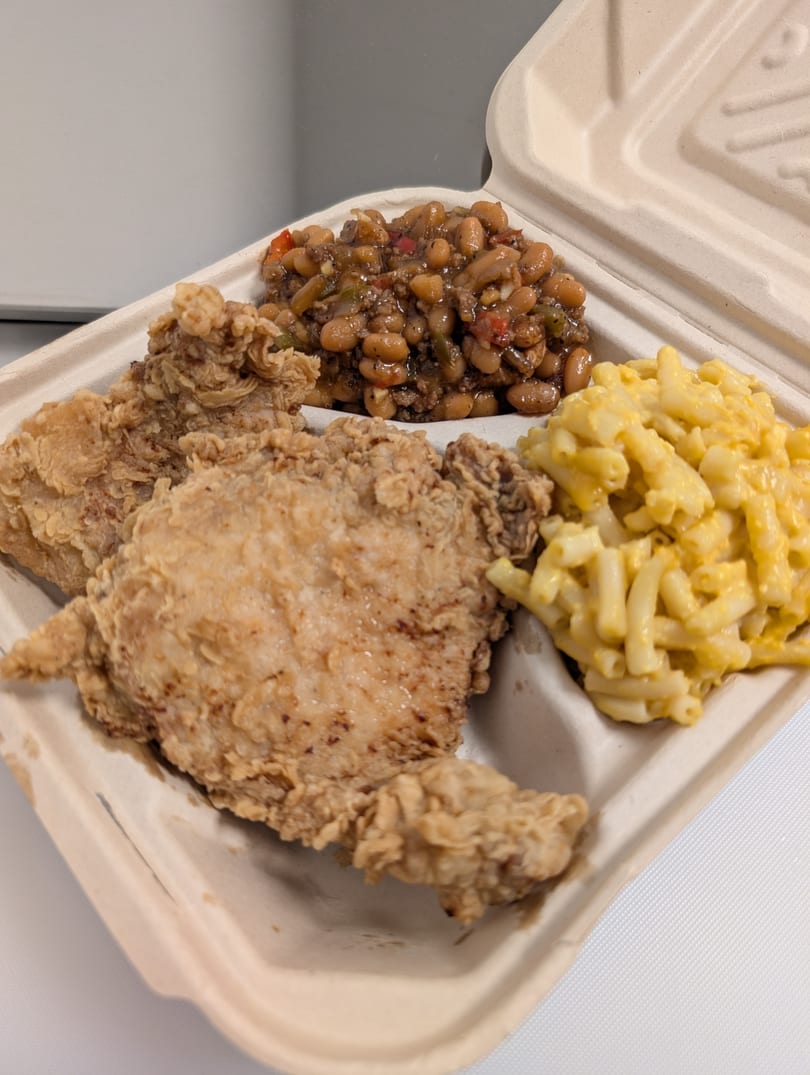 Fried chicken, baked beans, and macaroni and cheese in a takeout container from Cap Hill Burgers.